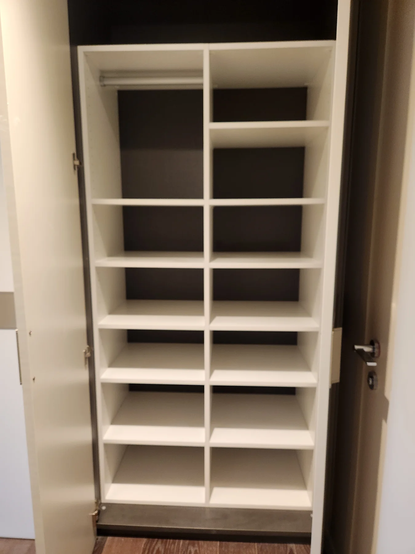 White adjustable shelving for shoes and smaller items inside a closet