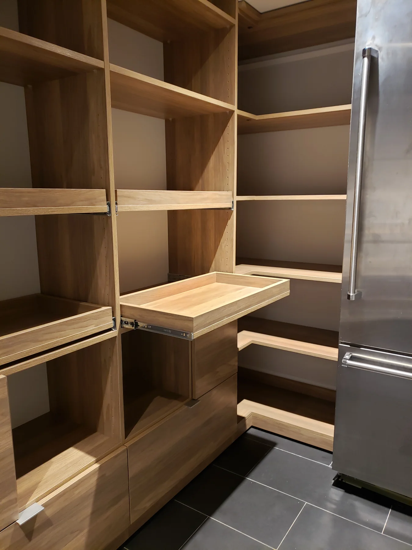 Shallow pantry tray extended beneath open storage shelves