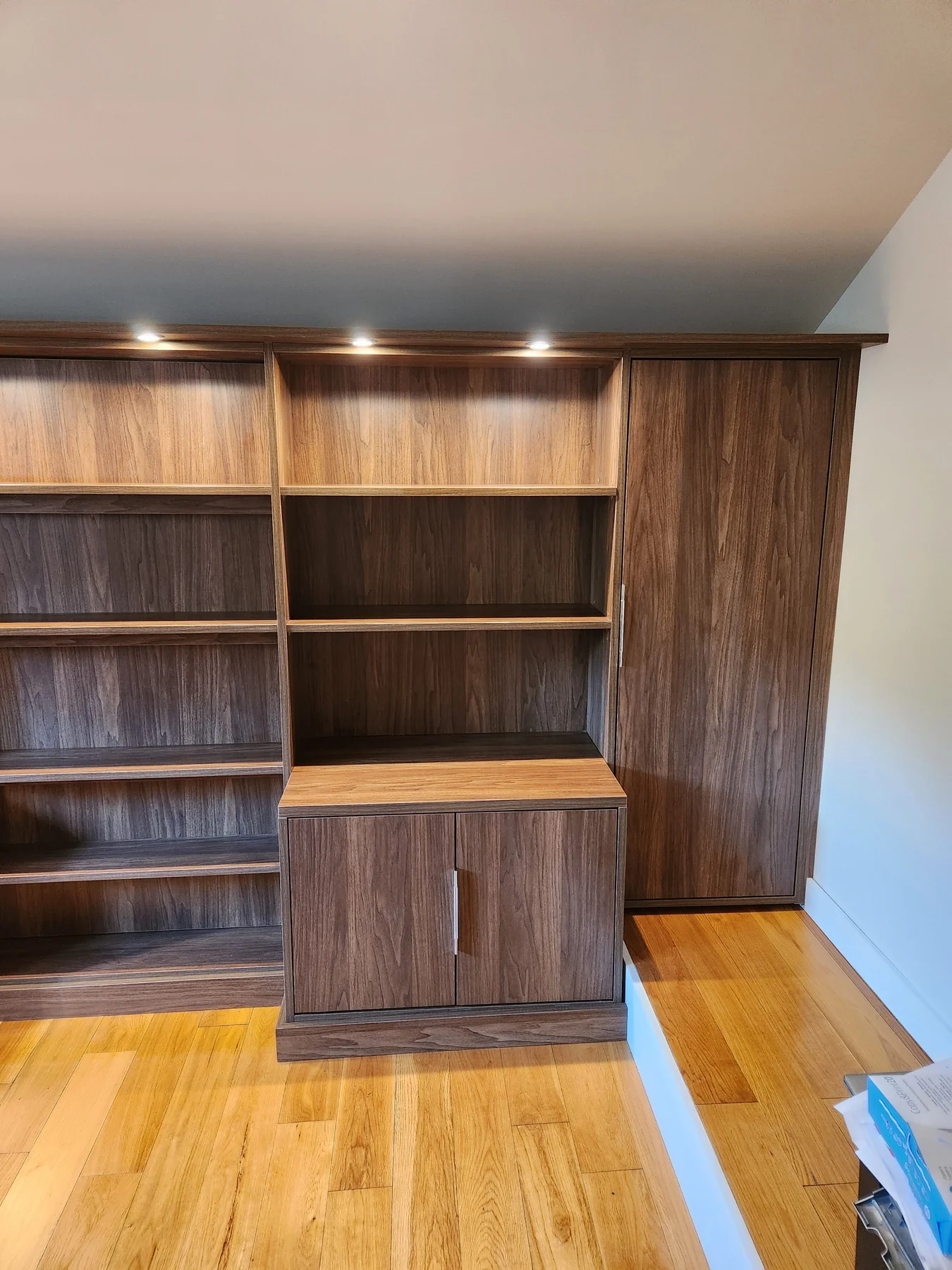 Library storage detail with open shelves and a wood-grain cupboard