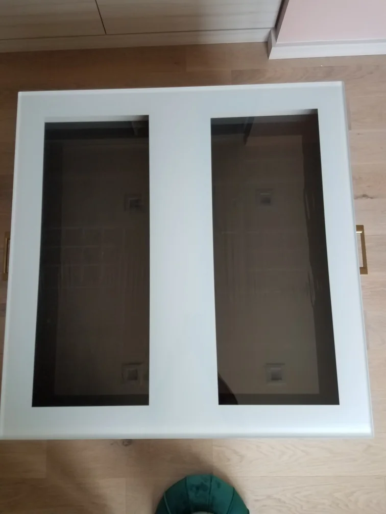 During fabrication: a white two-panel glass-front cabinet door laid out in the workshop before fitting
