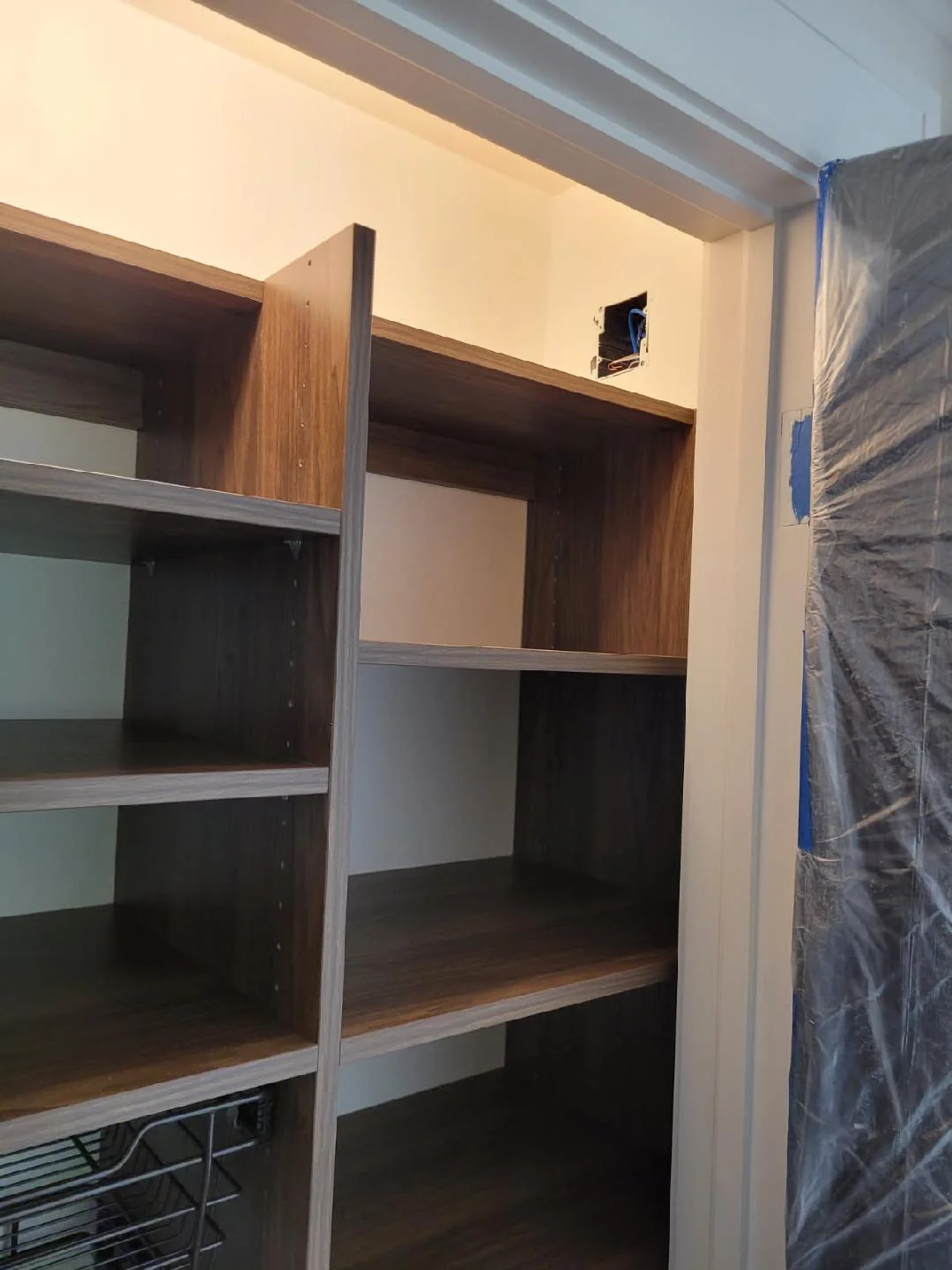 During installation: assembling the wood-grain closet shelving and drawer cabinet before the final trim and lighting were finished