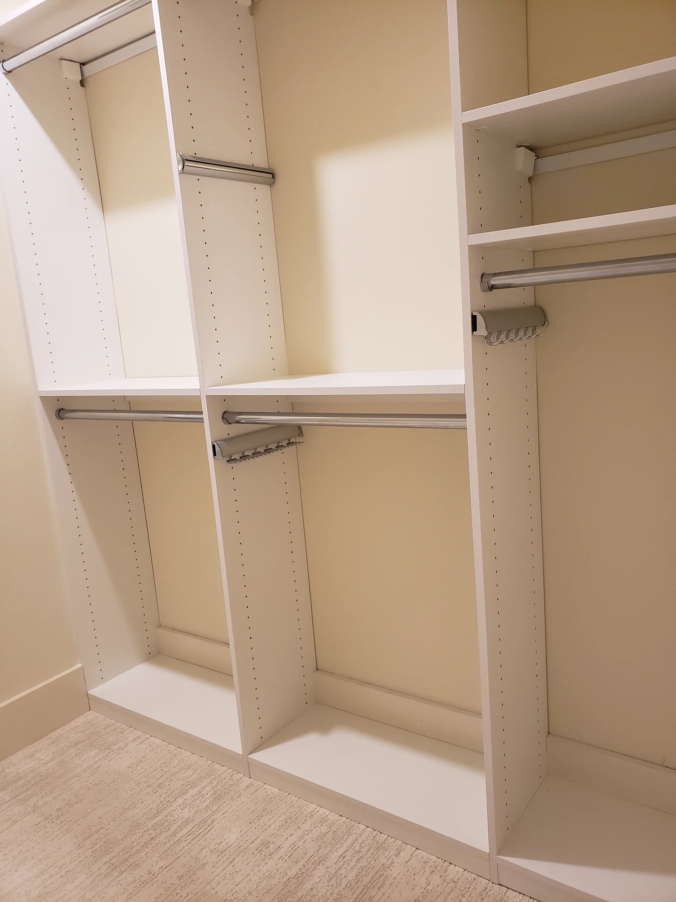 White hanging sections with adjustable shelves and metal rails