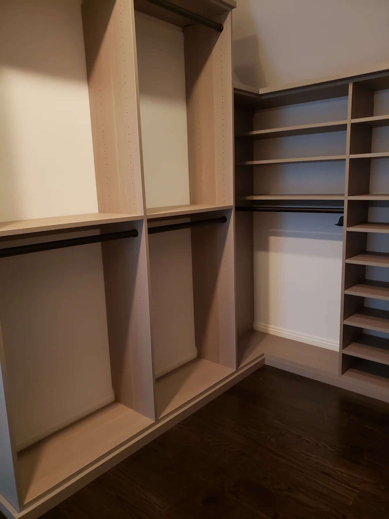 Opposite closet wall with upper storage, double hanging rails and low shelves