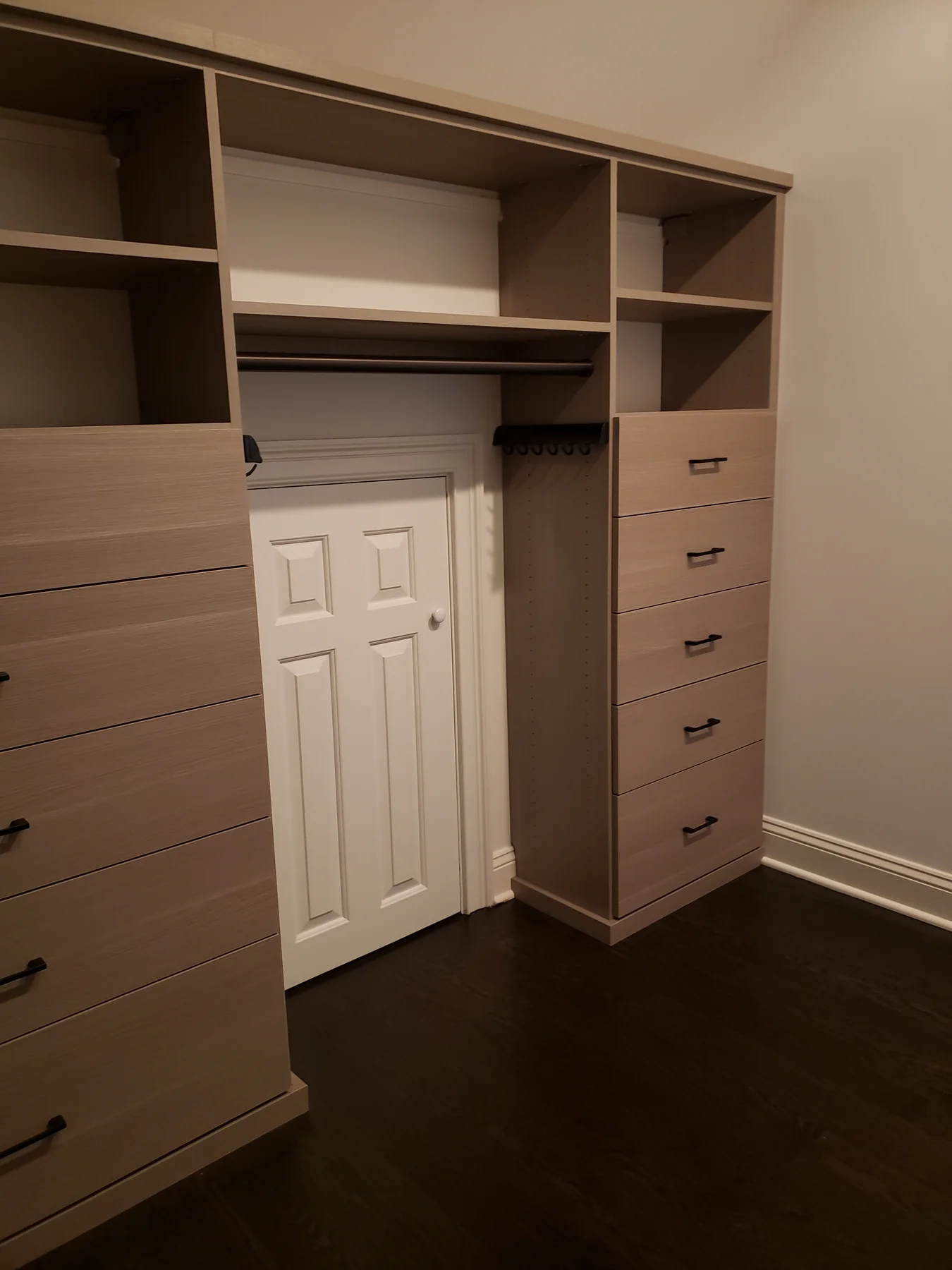 Two wood-finish drawer towers with storage above a small wall access door