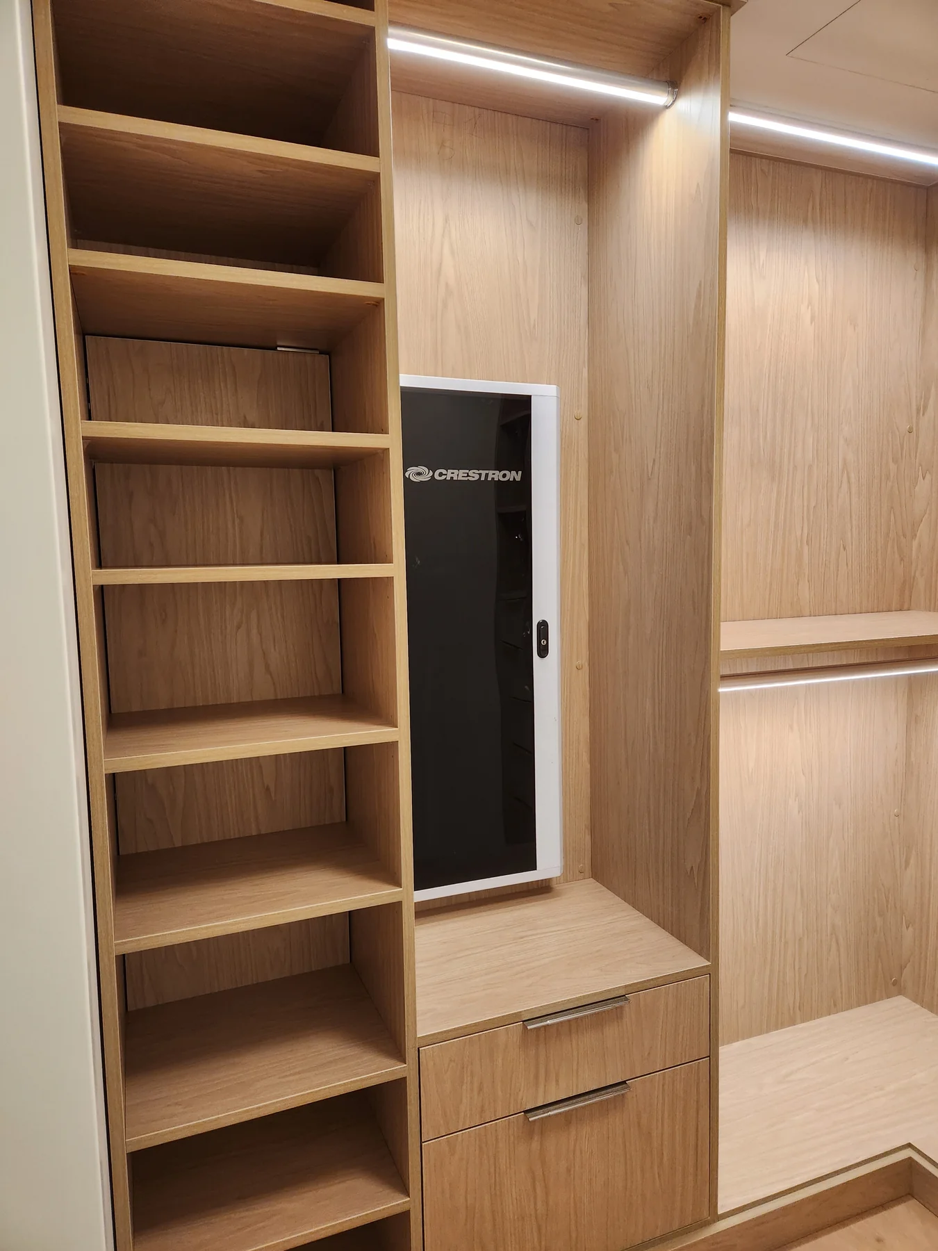 Wood-finish closet with shoe shelves, a fold-away ironing board and drawers
